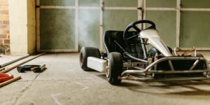 close-up of a parked go-kart in a dimly lit garage with tools on the floor