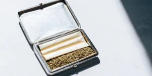 vintage silver cigarette case filled with cannabis and rolling papers
